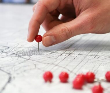 Hand putting pin in a map.
